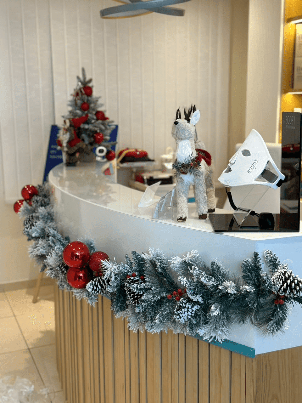 Reception counter dressed with a snowy garland, red ornaments and a small Christmas tree