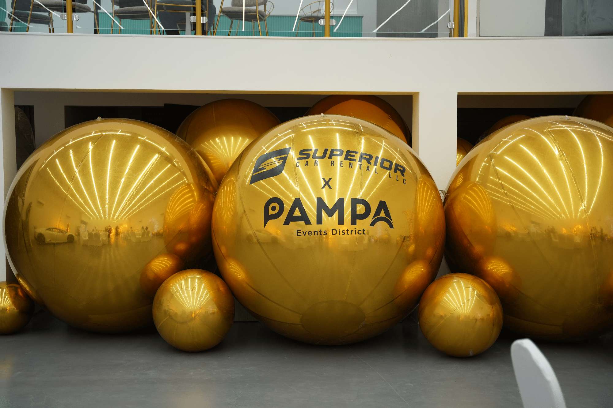 Gold giant bubbles printed with the Superior × Pampa Events District logos